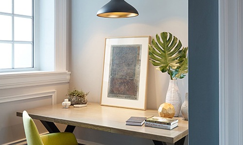 a desk with plant chair and window